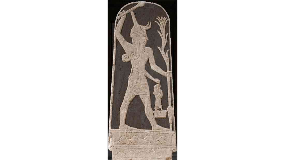 Stele of deity Ba'al brandishing his thunderbolt and planting his spear while attended by a king; currently at Louvre
