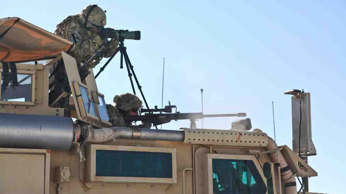 Soldiers firing from an armoured vehicle
